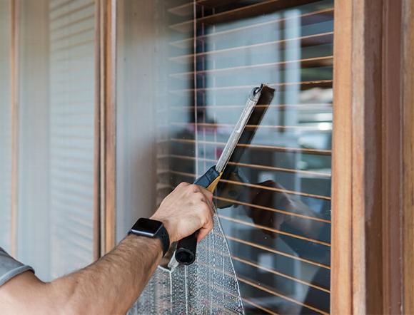 window cleaner using window wiper to clean office window